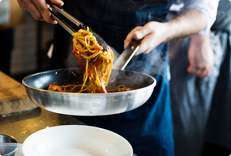 Chef cocinando en restaurante que redujo su gasto energético con Vatios Verdes